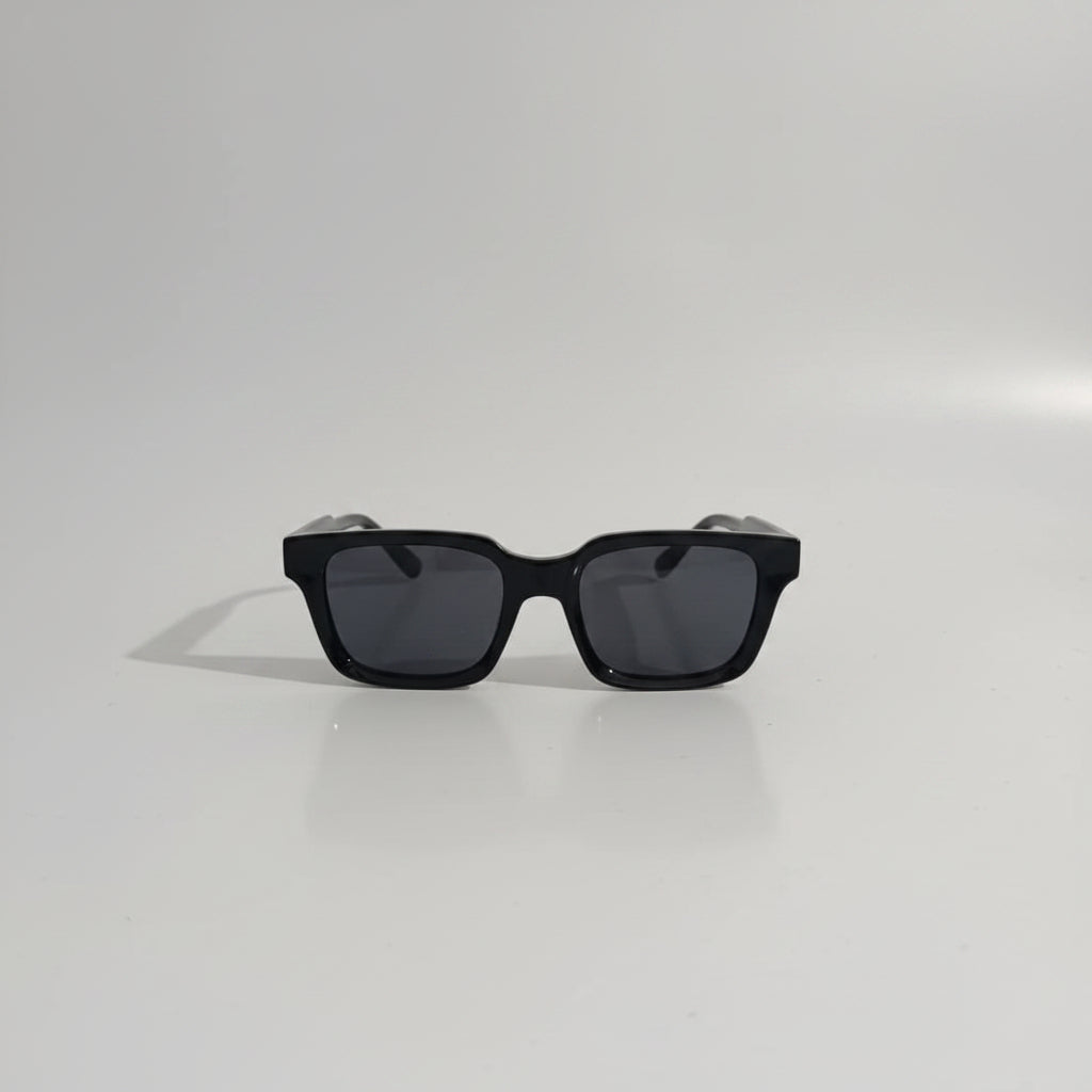 Black sunglasses on a white surface with a blurred background