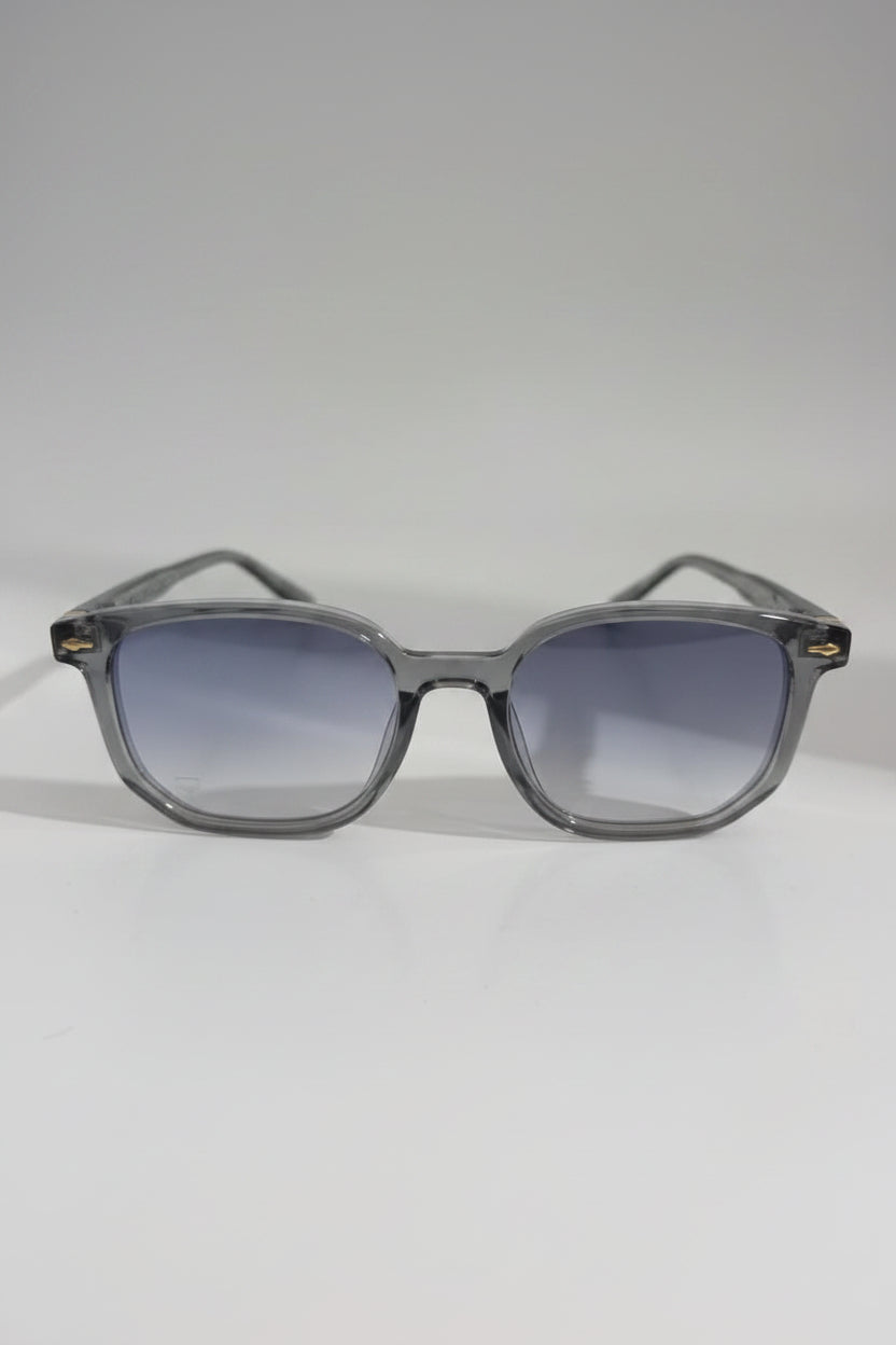 Clear frame sunglasses with gradient lenses on a white surface