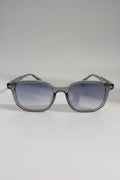Clear frame sunglasses with gradient lenses on a white surface