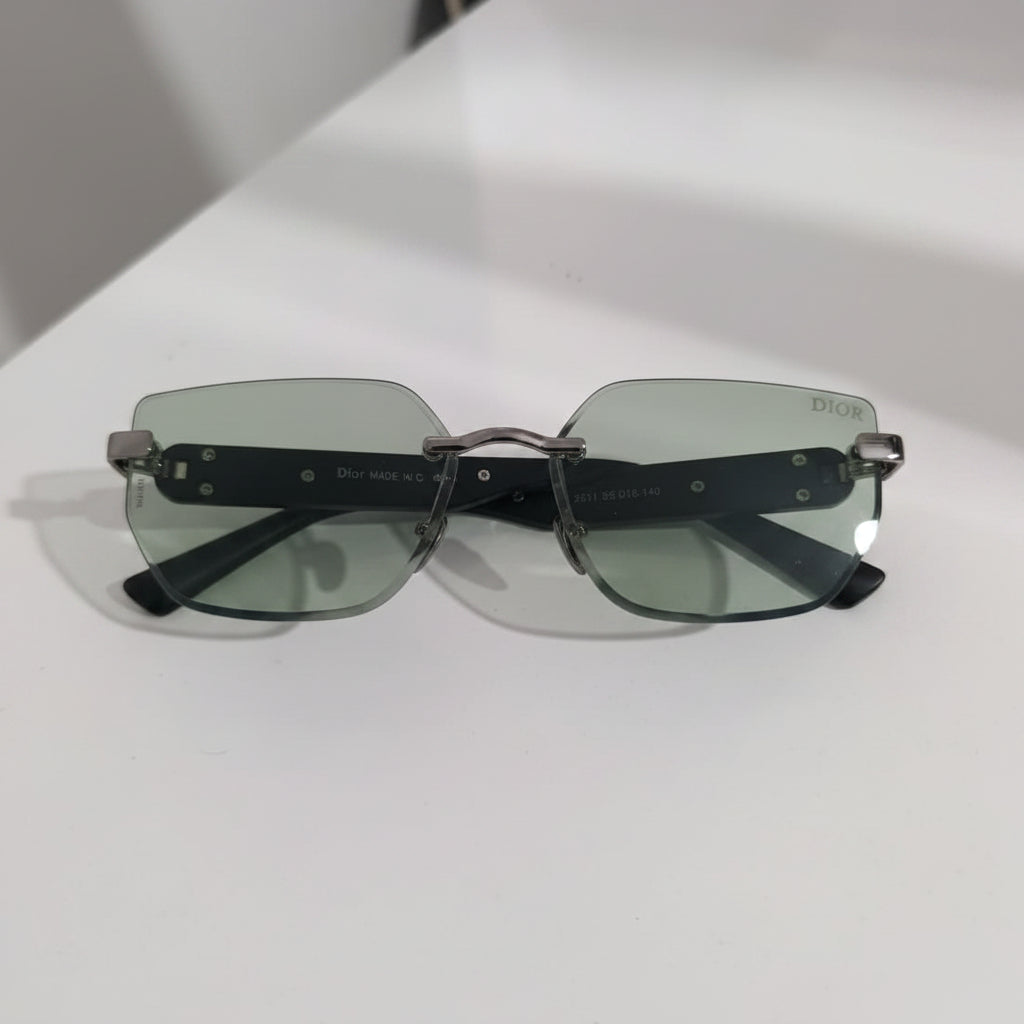 Sunglasses with green lenses on a white surface