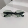Sunglasses with green lenses on a white surface