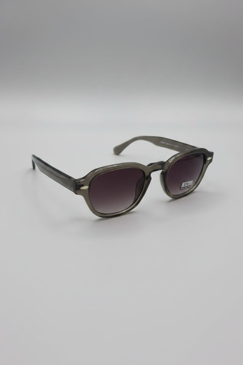 Pair of sunglasses on a reflective surface with a blurred background