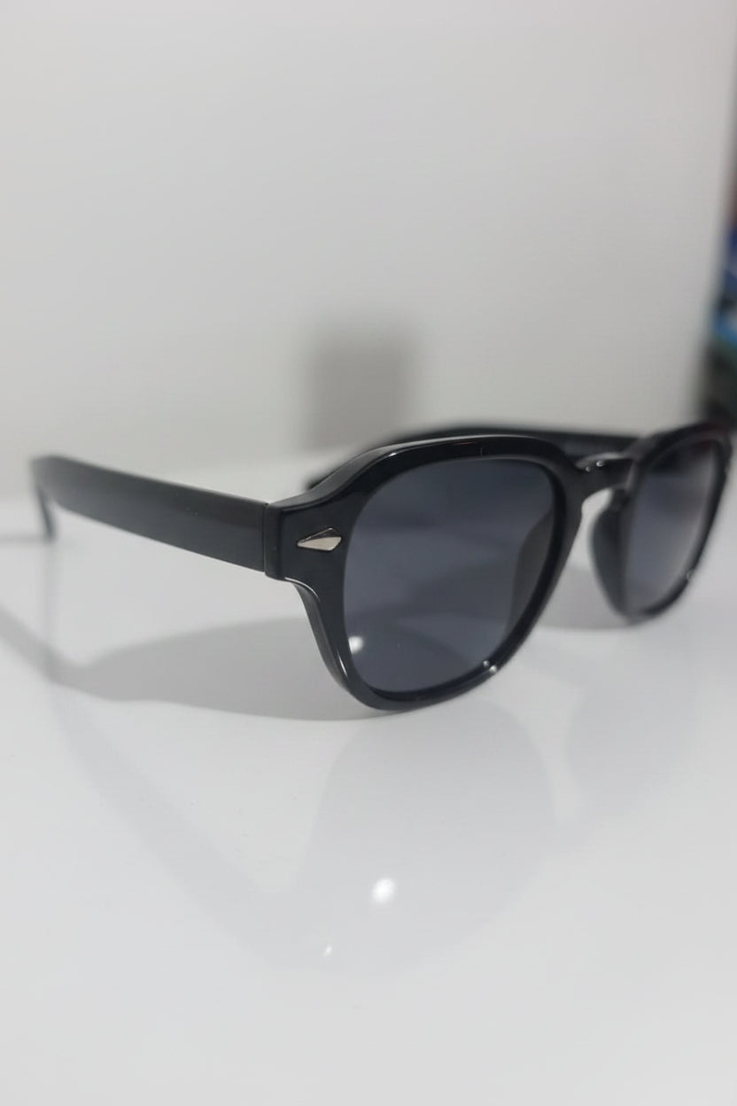Black sunglasses on a white surface with a blurred background