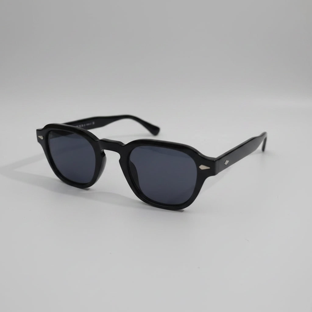 Black sunglasses with dark lenses on a white surface