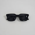 Black sunglasses on a white surface