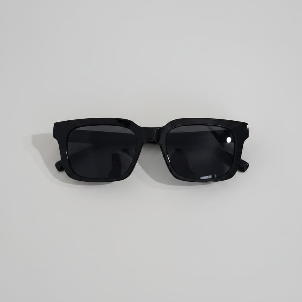 Black sunglasses on a white surface