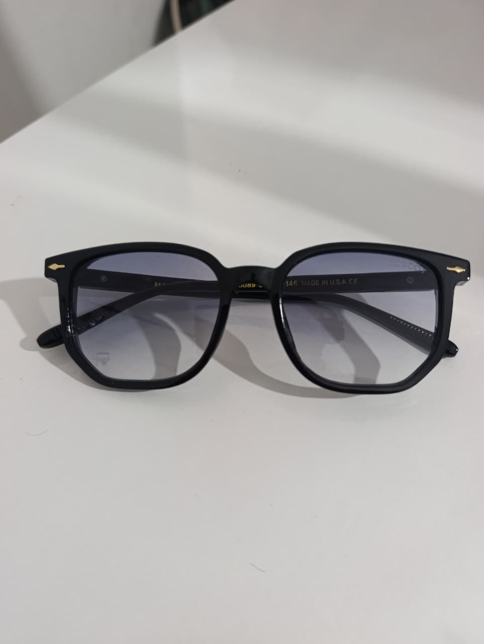 Black sunglasses on a white surface